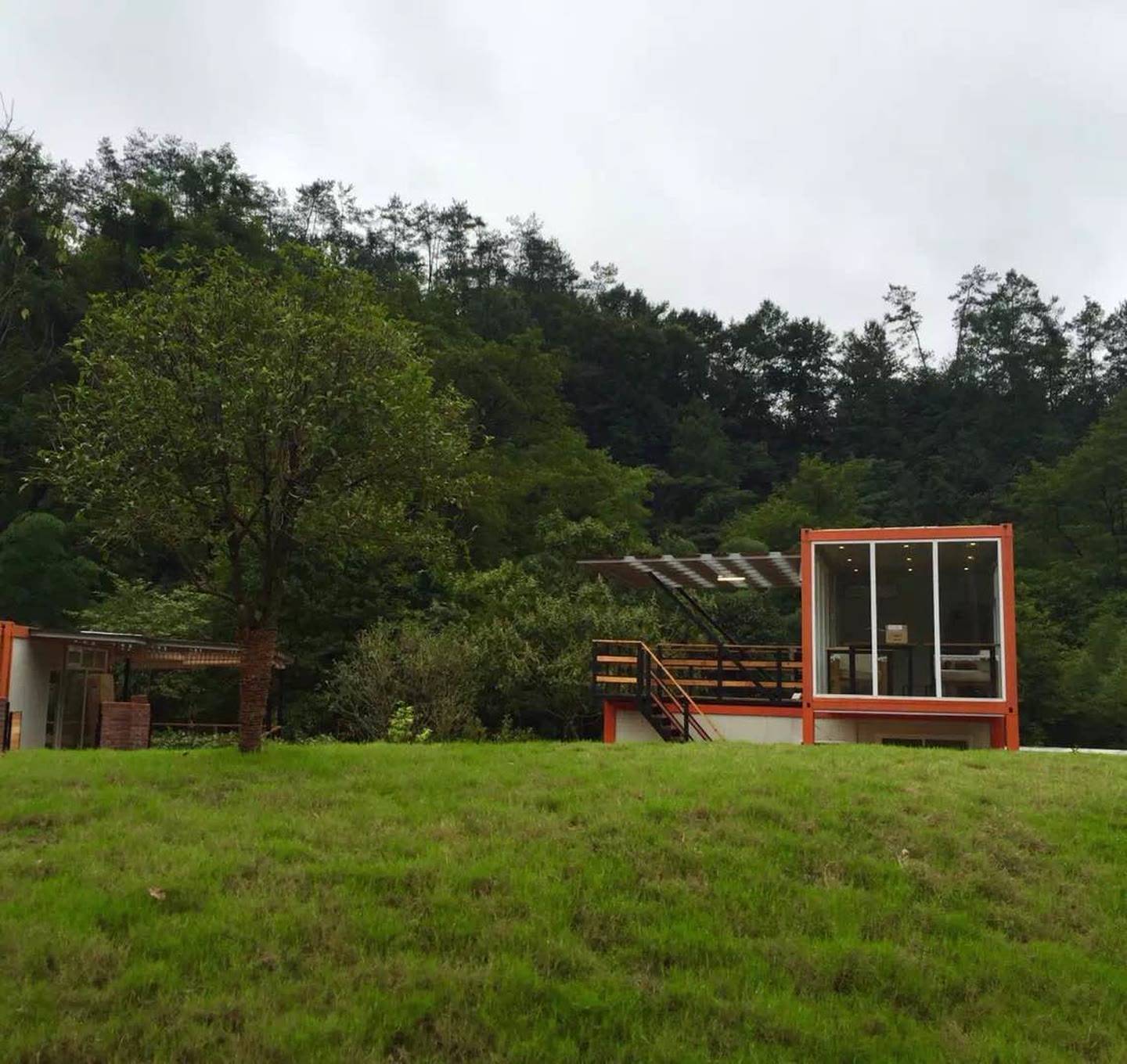 Container clubhouse viewed across a landscaped lawn