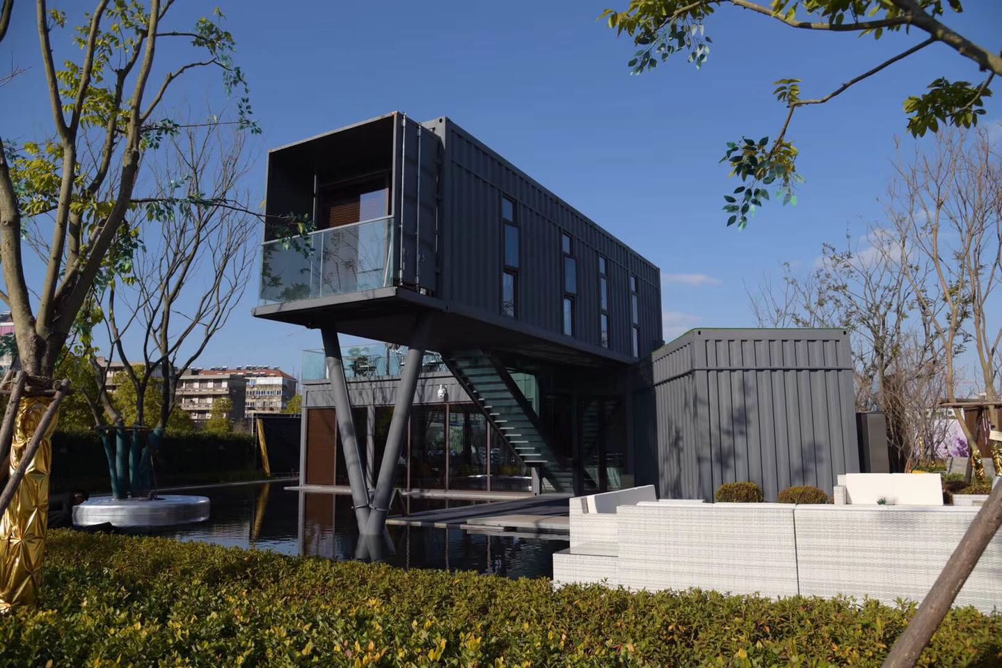 Completed dark container sales pavilion in a landscaped setting